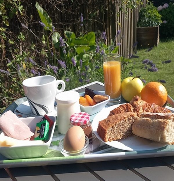Petit-déjeuner servi en extérieur avec jus, viennoiseries et fruits à l’hôtel à Biscarrosse Plage dans les Landes